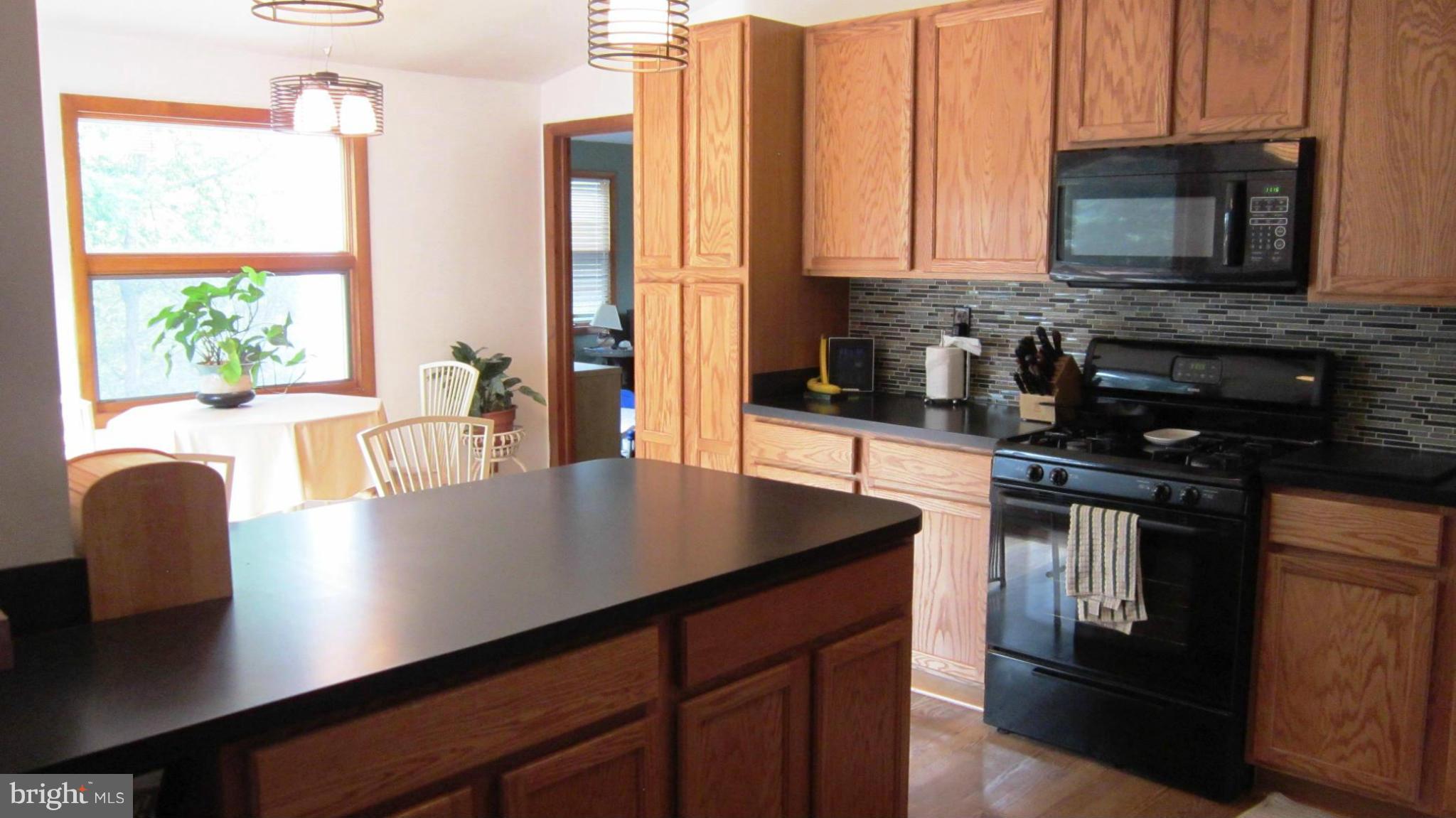 17030 Hughes Road Poolesville, MD 20837 - Photo 5 of 24 a kitchen with stainless steel appliances a stove a microwave a sink and cabinets