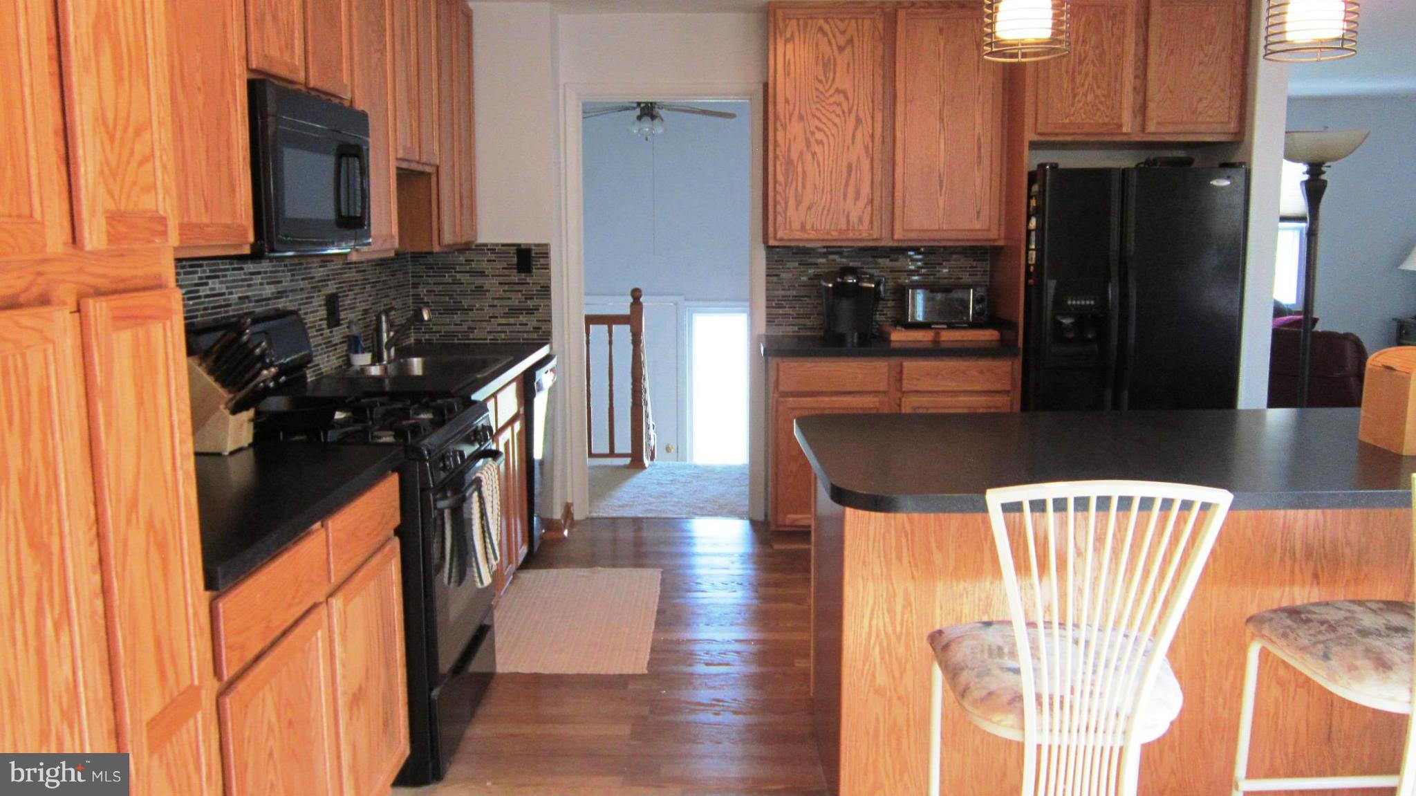17030 Hughes Road Poolesville, MD 20837 - Photo 6 of 24 a kitchen with stainless steel appliances granite countertop a refrigerator a stove top oven a sink and dishwasher