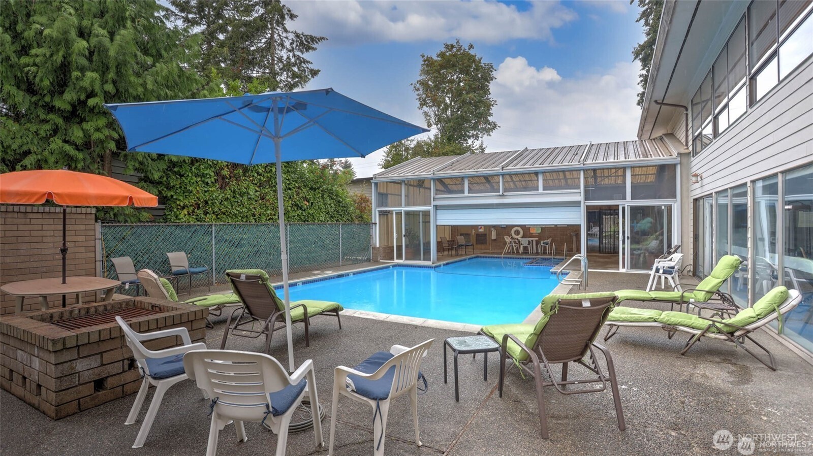 201 Union Avenue Southeast, Unit 247 Renton, WA 98059 - Photo 23 of 32 a view of a patio with a dining table and chairs under an umbrella with barbeque grill and wooden floor