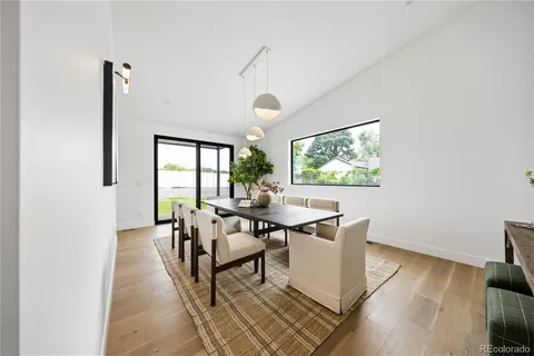 a dining room with wooden floor and a chandelier