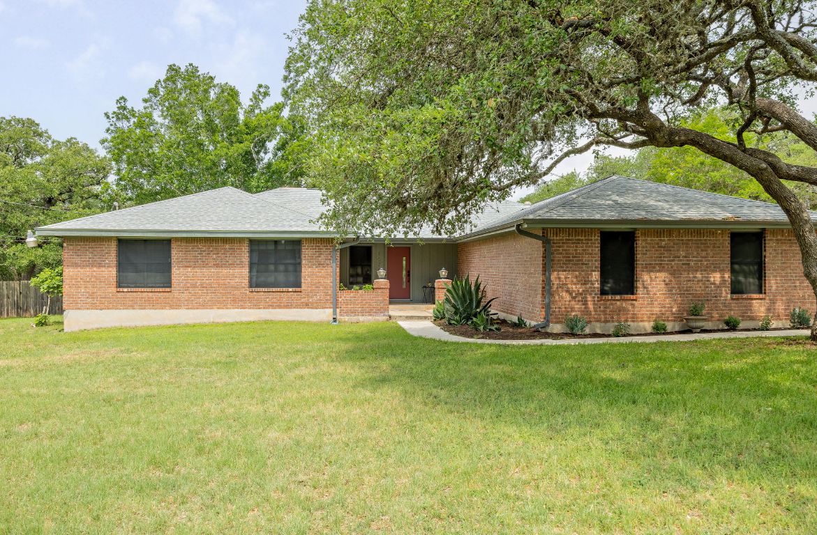 a front view of a house with a garden and yard