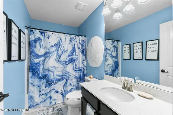 a bathroom with a sink mirror vanity and toilet