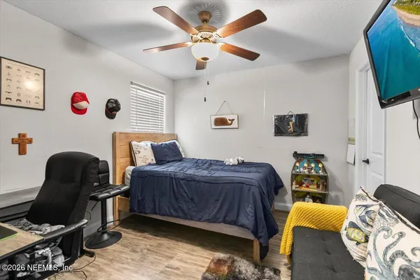 a bedroom with a bed and wooden floor