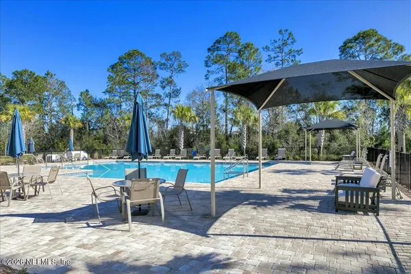 a view of a patio with a table and chairs under an umbrella