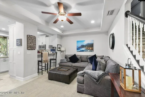 a living room with furniture a ceiling fan and a window