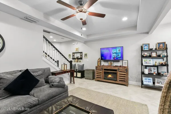 a living room with furniture and a flat screen tv with wooden floor
