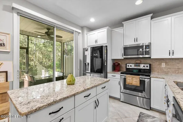 a kitchen with stainless steel appliances granite countertop a stove a sink and a refrigerator