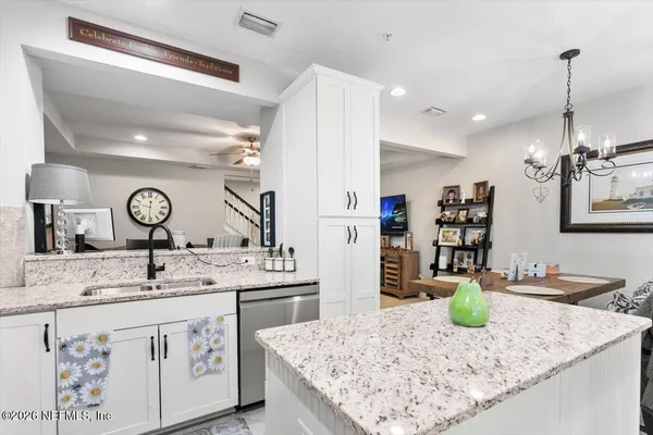 a kitchen with stainless steel appliances granite countertop a sink a stove and a wooden floors