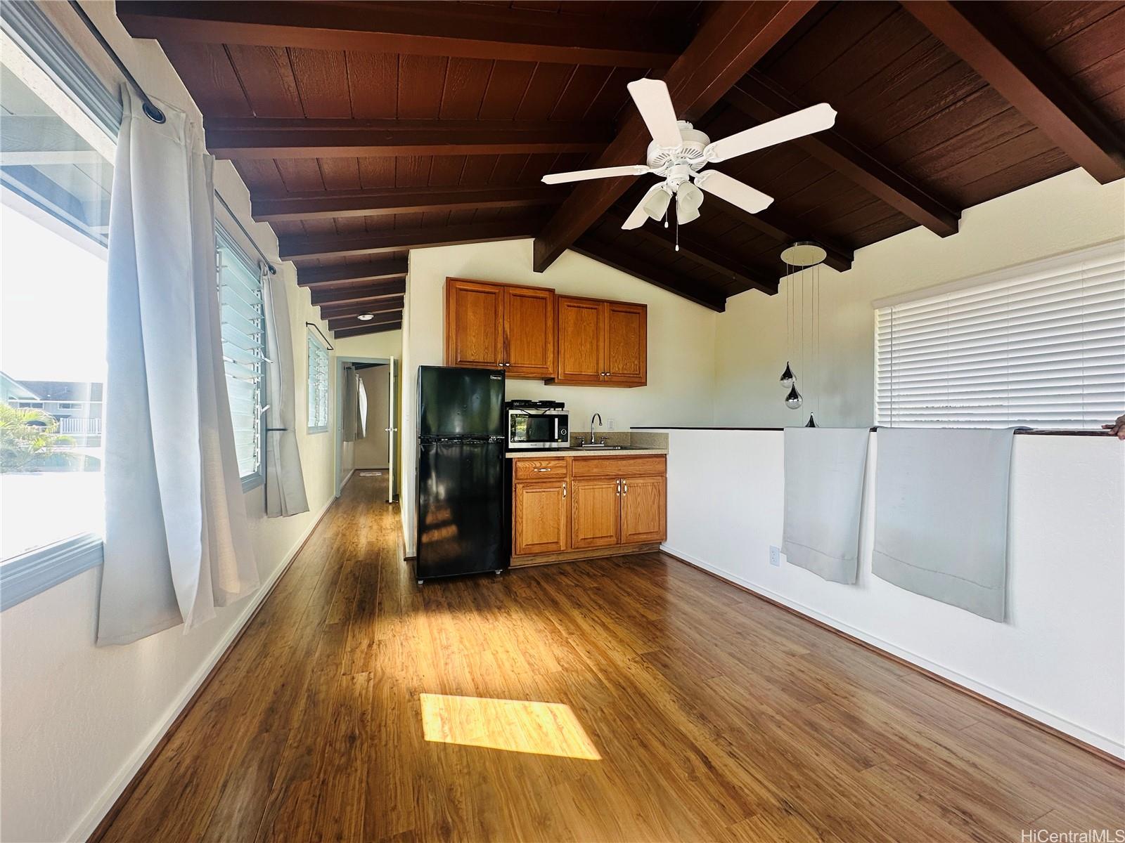 a view of a kitchen with wooden floor a ceiling fan a ceiling fan and wooden floor