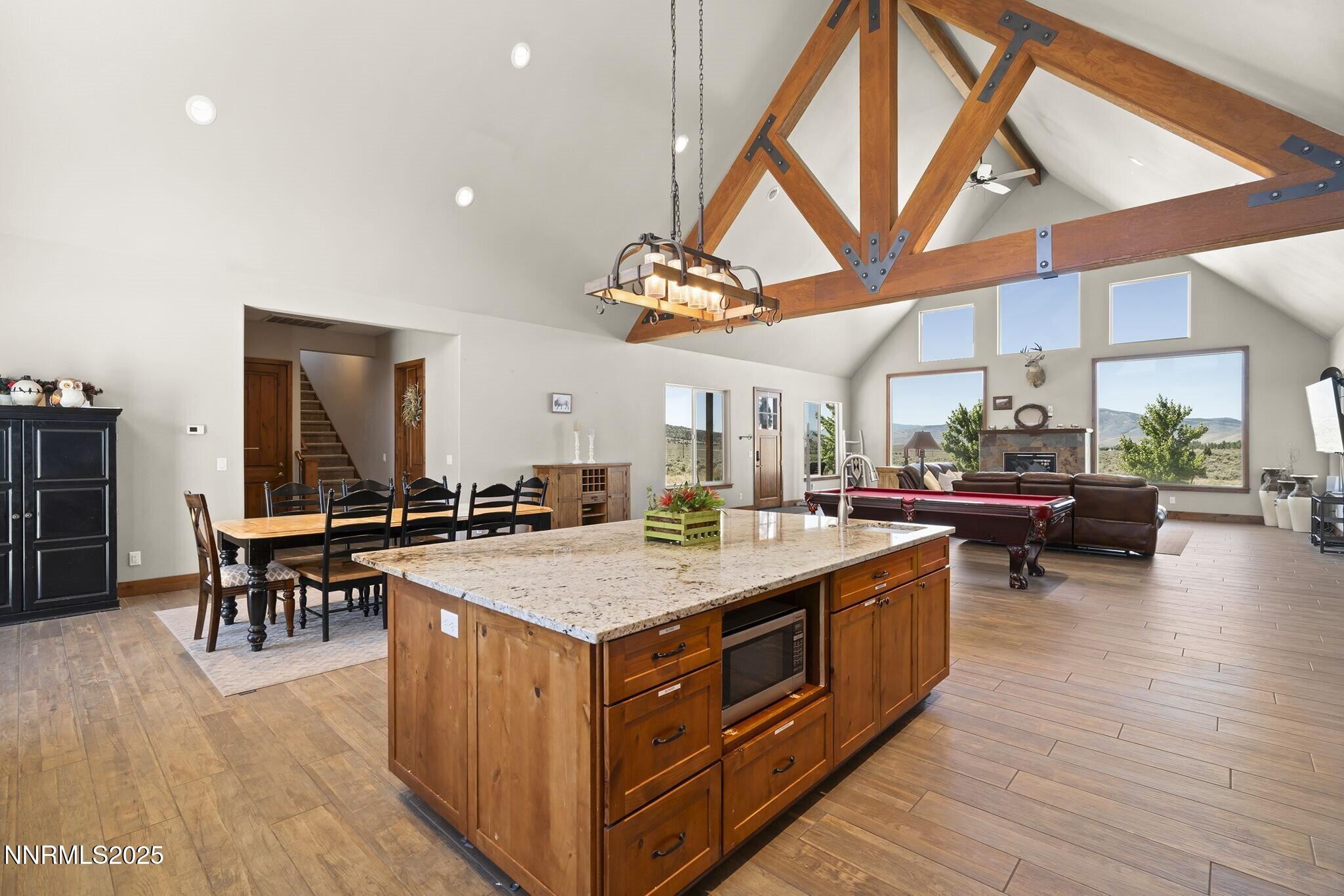 1240 Antelope Valley Road Reno, NV 89508 - Photo 15 of 60 a kitchen with a stove a kitchen island a dining table and chairs with wooden floor