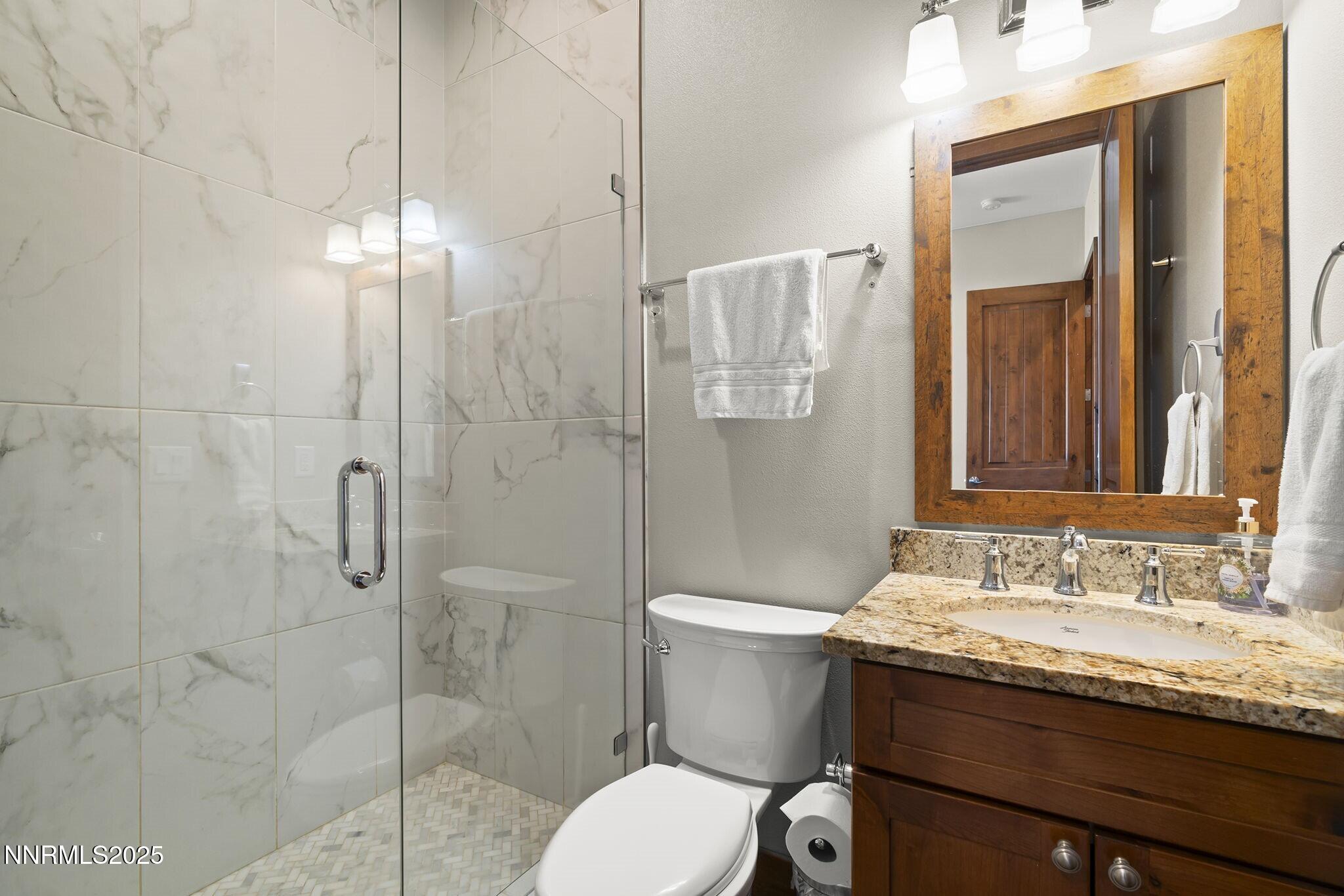 1240 Antelope Valley Road Reno, NV 89508 - Photo 17 of 60 a bathroom with a granite countertop sink toilet a mirror and shower