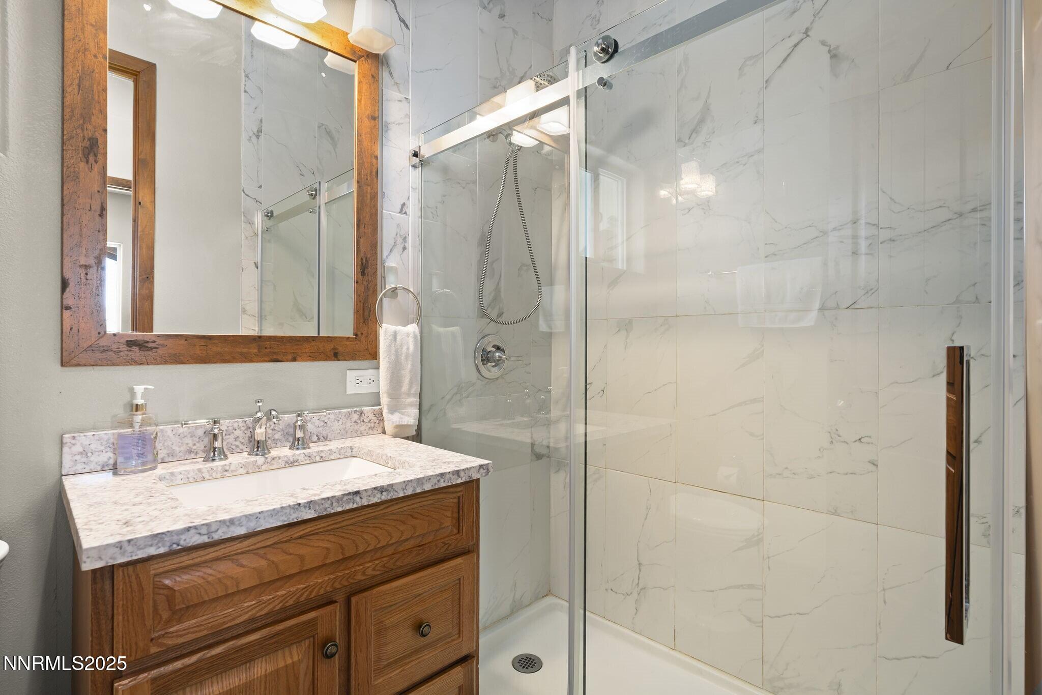 1240 Antelope Valley Road Reno, NV 89508 - Photo 26 of 60 a bathroom with a granite countertop sink a shower and a mirror
