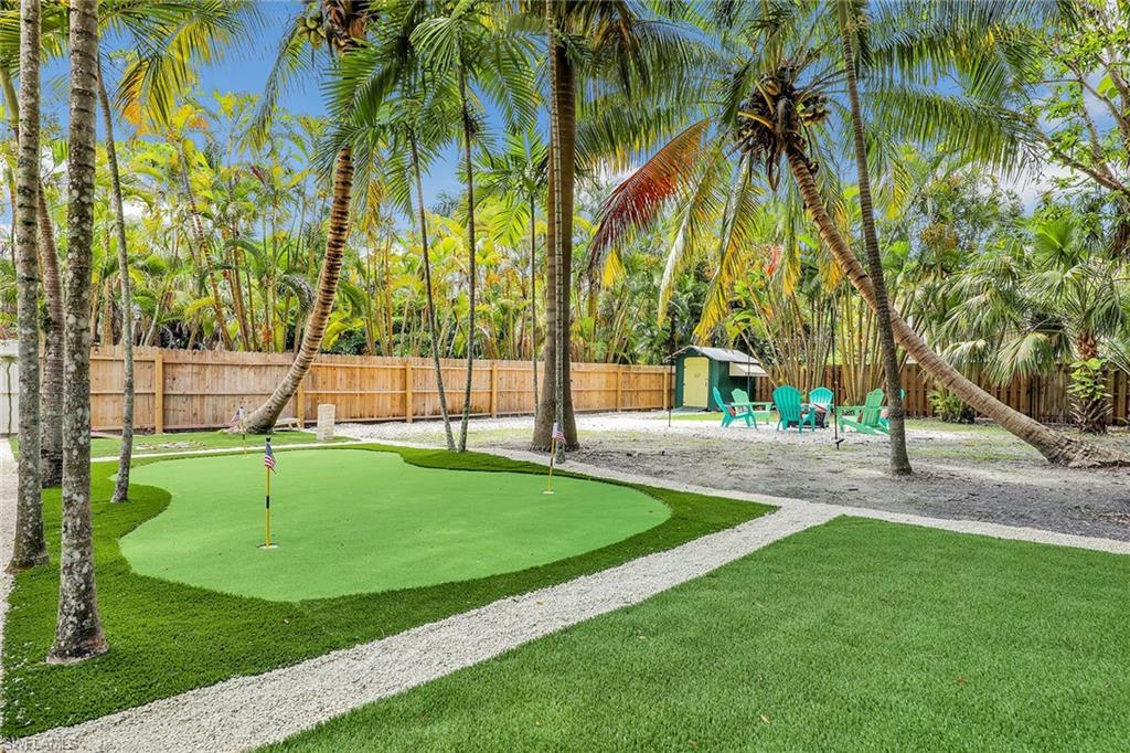 2780 Weeks Avenue Naples, FL 34112 - Photo 18 of 34 a view of swimming pool with a garden and trees