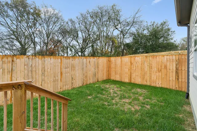 a view of backyard with wooden fence
