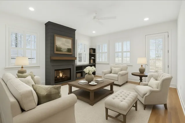 a living room with furniture fireplace and a large window