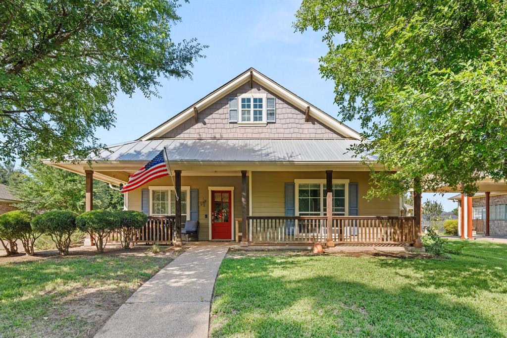 10609 Aquilla Trail Waco, TX 76708 - Photo 7 of 30 Craftsman-style exterior featuring a red front door, covered porch with wooden railings, and a metal roof