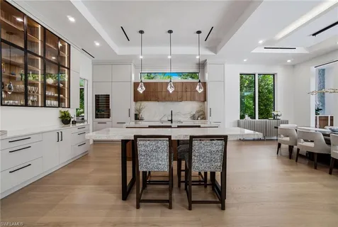 a kitchen with stainless steel appliances granite countertop table chairs sink and window