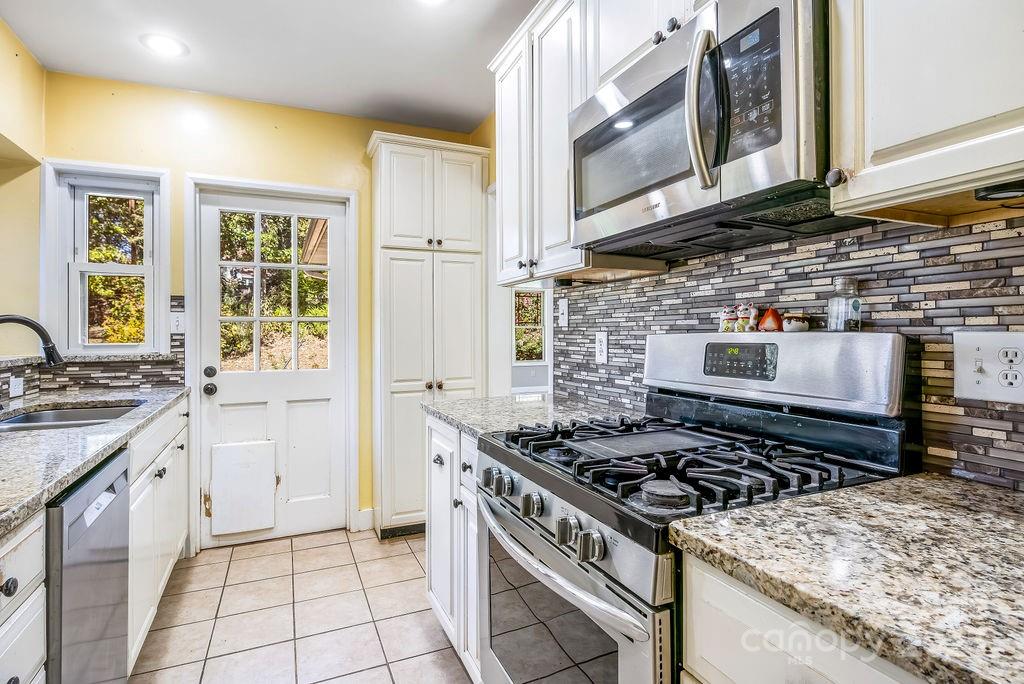 145 Beverly Road Asheville, NC 28805 - Photo 12 of 45 a kitchen with a stove a sink and a microwave
