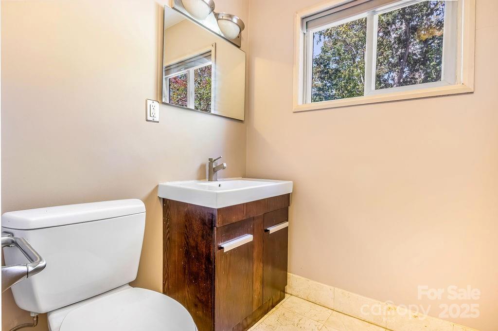 145 Beverly Road Asheville, NC 28805 - Photo 17 of 45 a bathroom with a toilet sink and mirror