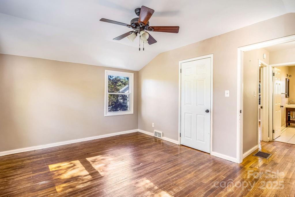 145 Beverly Road Asheville, NC 28805 - Photo 19 of 45 a view of a bedroom with wooden floor and a ceiling fan