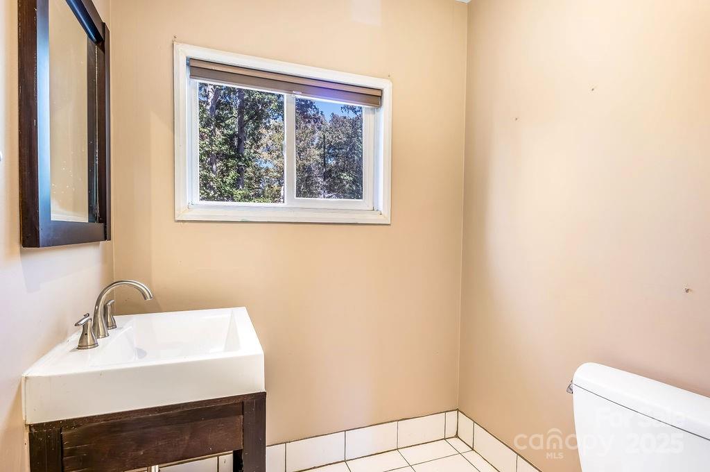 145 Beverly Road Asheville, NC 28805 - Photo 22 of 45 a bathroom with a sink a toilet and a mirror