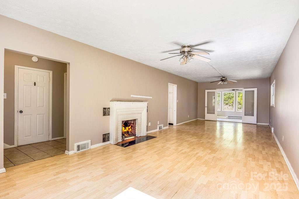 145 Beverly Road Asheville, NC 28805 - Photo 31 of 45 a view of a livingroom with a fireplace and a chandelier fan