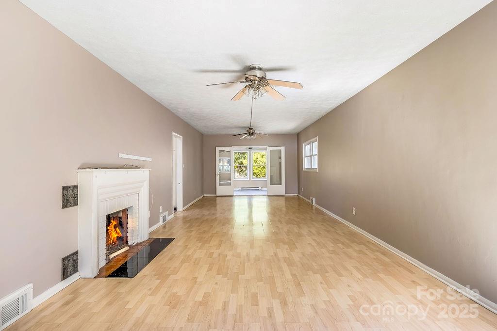 145 Beverly Road Asheville, NC 28805 - Photo 33 of 45 a view of empty room with a fireplace ceiling fan and window