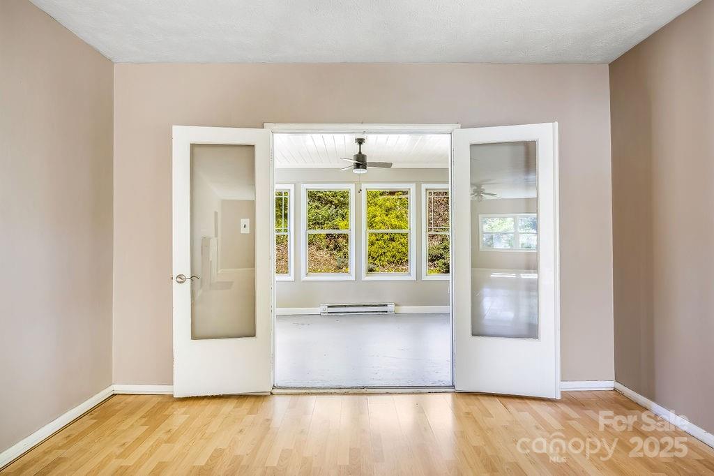 145 Beverly Road Asheville, NC 28805 - Photo 5 of 45 a view of an empty room with wooden floor and a window