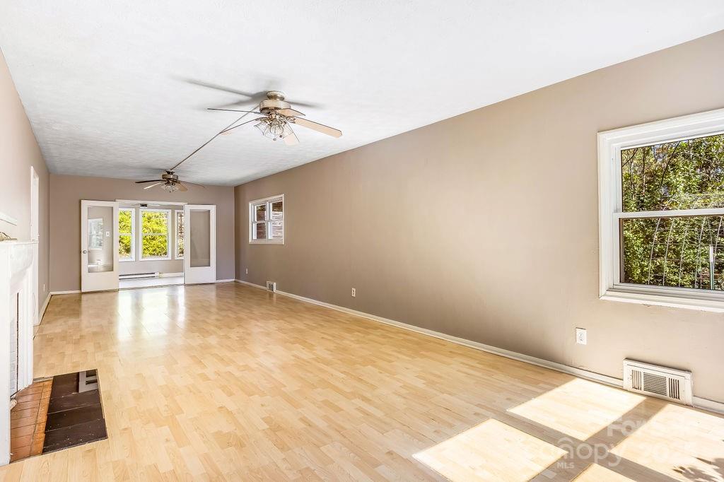 145 Beverly Road Asheville, NC 28805 - Photo 9 of 45 an empty room with windows and ceiling fan