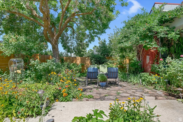 510 Spring Creek Road Providence, UT 84332 - Photo 67 of 97 Mature trees shade an expansive backyard featuring a stone patio and vibrant garden beds