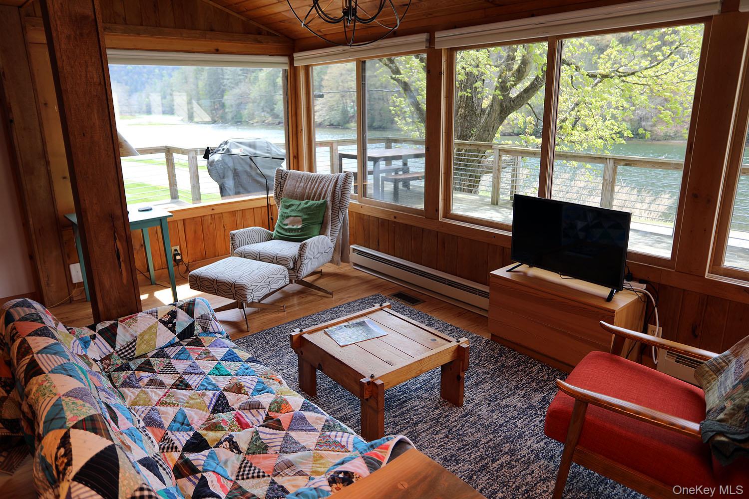 5120 Peas Eddy Road Hancock, NY 13783 - Photo 9 of 37 a living room with furniture a rug and a floor to ceiling window