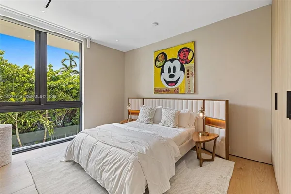 a bedroom with a bed and a painting on the wall