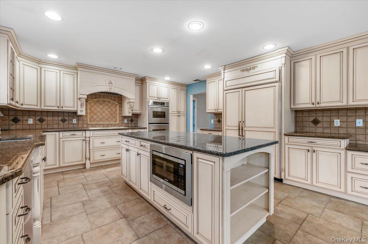 Undisclosed Address Bellmore, NY 11710 - Photo 12 of 30 a kitchen with granite countertop a stove sink and cabinets