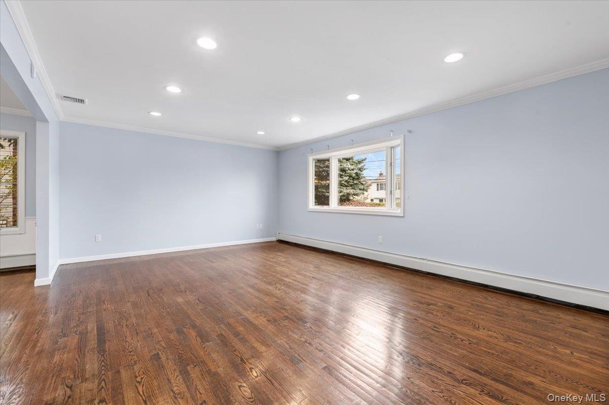 Undisclosed Address Bellmore, NY 11710 - Photo 2 of 30 a view of an empty room with wooden floor and a window