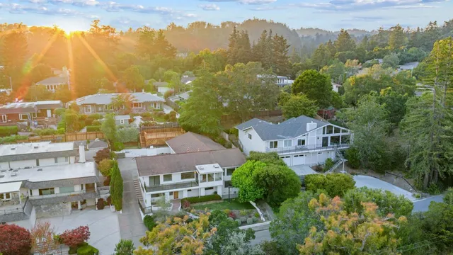 an aerial view of multiple houses with a yard