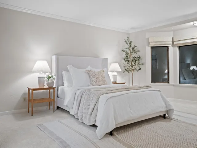 a bedroom with a bed and a potted plant