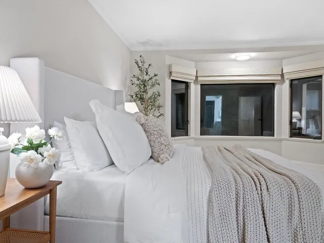 a bedroom with a bed and a potted plant