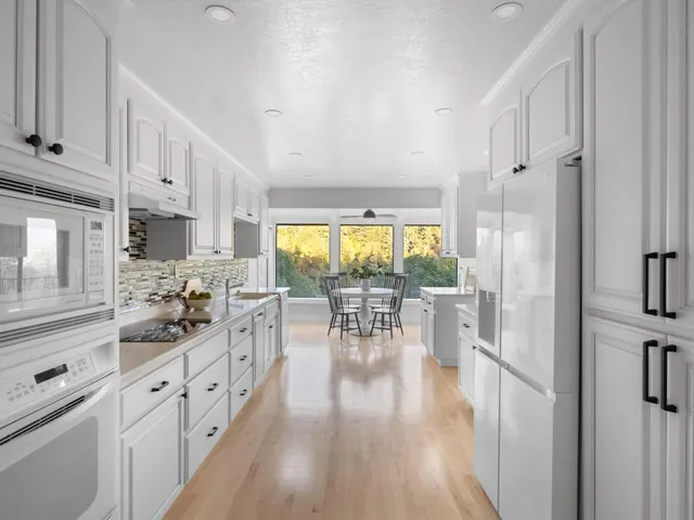 a kitchen with white cabinets and sink