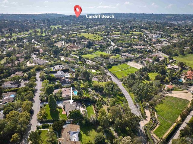 an aerial view of residential houses with outdoor space and trees