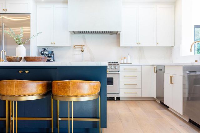 a kitchen with a table chairs refrigerator and cabinets