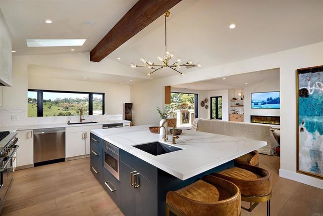 a kitchen with a stove a sink dishwasher and a refrigerator with wooden floor