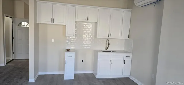a kitchen with white cabinets and sink