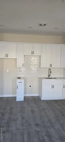 a kitchen with granite countertop white cabinets and white appliances