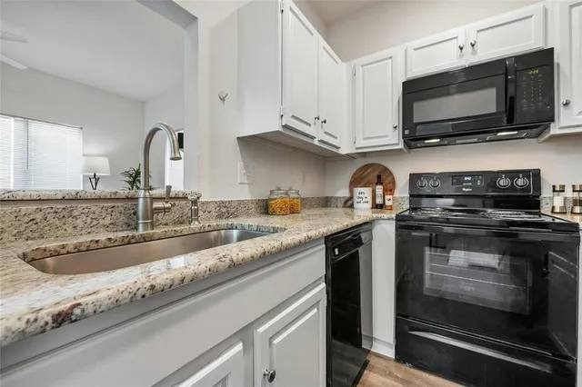 a kitchen with stainless steel appliances granite countertop a sink stove and microwave