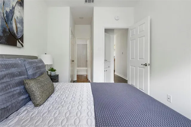 a bedroom with a bed and a flat tv screen on dresser