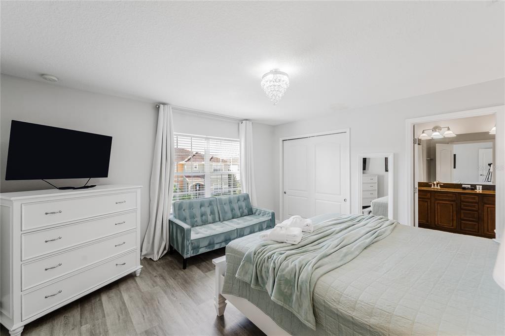 8961 Majesty Palm Road Kissimmee, FL 34747 - Photo 21 of 40 a bedroom with a bed and a flat tv screen in it