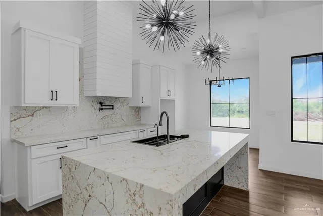 a kitchen with stainless steel appliances a white counter top a sink a window and cabinets