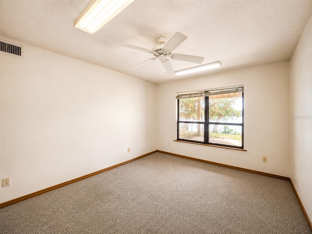 7119 Immokalee Road Keystone Heights, FL 32656 - Photo 37 of 50 an empty room with chandelier fan and windows