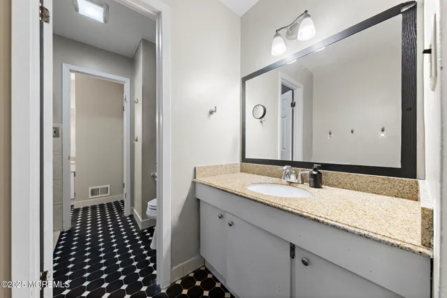 a bathroom with a granite countertop sink a mirror and a shower