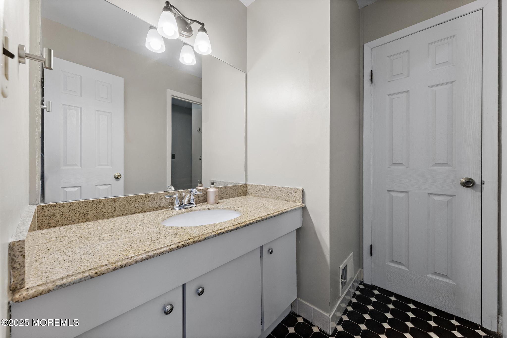343 Middlewood Road Middletown, NJ 07748 - Photo 25 of 30 a bathroom with a granite countertop sink and a mirror